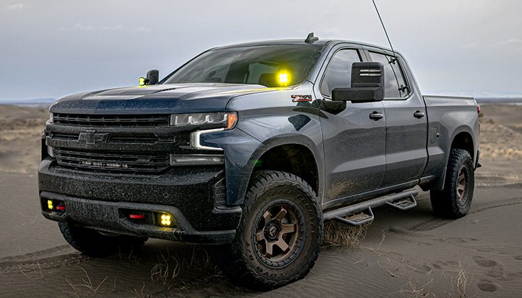 Chevrolet Silverado 1500 2020 Blue in the sand with Baja Designs lights on.