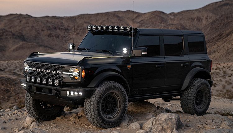 Black Ford Bronco in the desert at dusk with Baja Designs lights