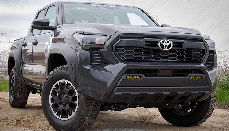 2024 Toyota Tacoma, Black 3/4 view with wheels turned to the left.